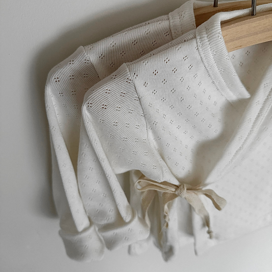 Two thirteen pointelle wrapped vest wit